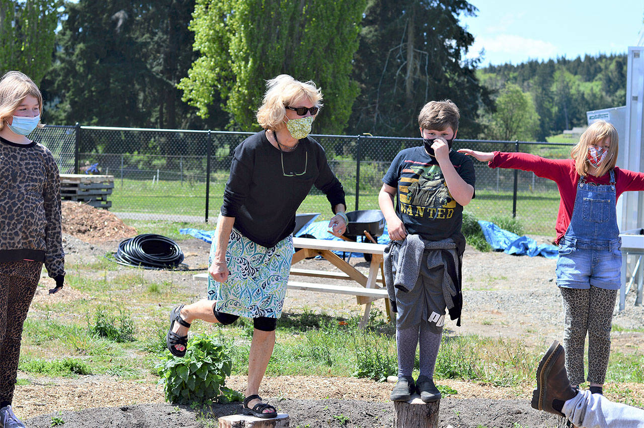 Practicing their balance in a garden at Chimacum Elementary School are, from left, Violet Weidner, 10, fourth-grade teacher Kit Pennell, Brycen Christiansen, 10, and Cora Van Otten, 9. (Diane Urbani de la Paz/Peninsula Daily News)