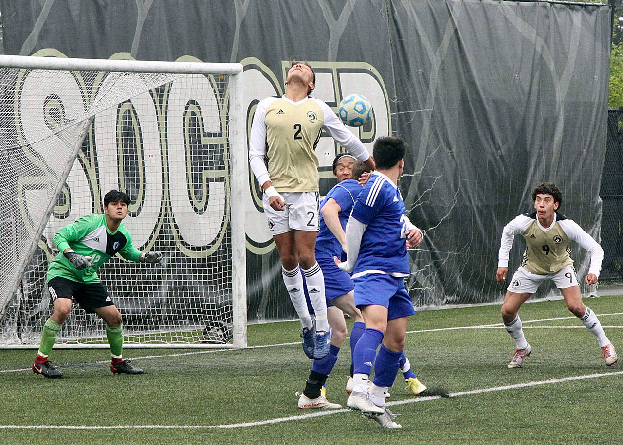 Peninsula’s Christopher Dominguez just misses a header into the goal of the Edmonds Tritons. Nicolas Hernandez (9) looks on. (Dave Logan/for Peninsula Daily News)