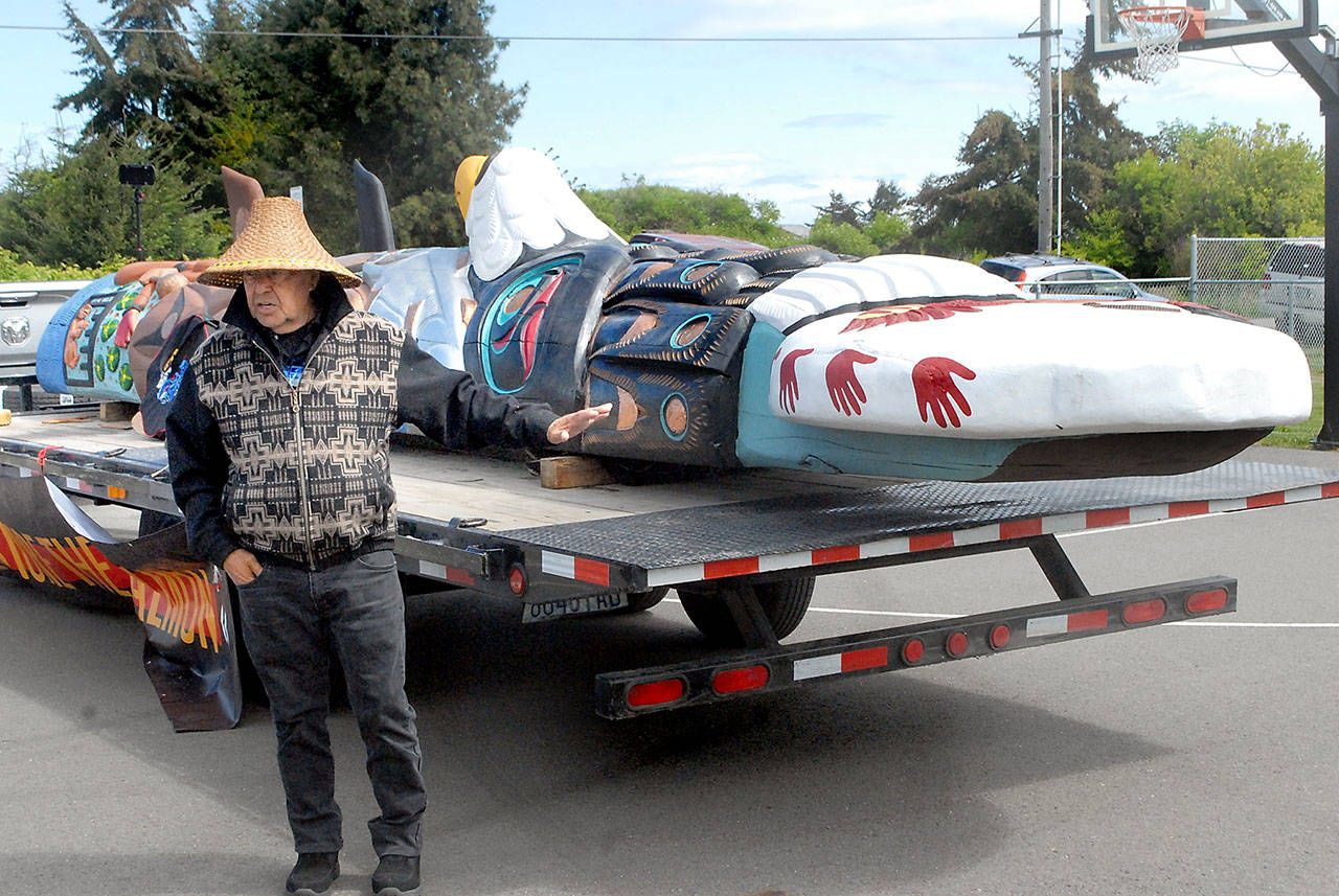 Lummi Nation totem carver Sit ki kadem, also called Doug James, explains the meaning of the elements of a totem that is traveling the United States on its way to Washington, D.C., during a stop on Tuesday at the Lower Elwha Reservation near Port Angeles. The journey, dubbed the Red Road to D.C., included a stop at the Olympic Unitarian Universalist Fellowship in Sequim on Tuesday. The 25-foot totem will be featured this fall at the Smithsonian National Museum of the American Indian. It is scheduled to return May 25 for an appearance at Port Angeles City Pier. (Keith Thorpe/Peninsula Daily News)