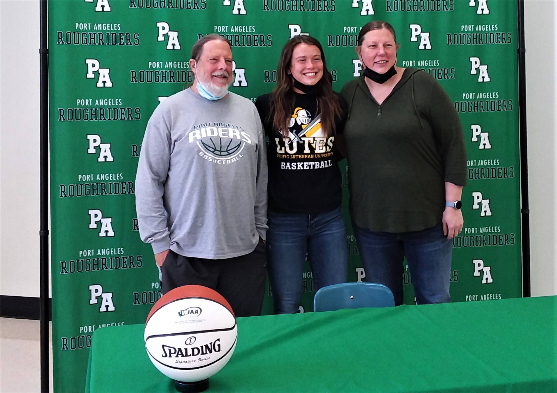 Port Angeles girls basketball coach Michael Poindexter, Jaida Wood and junior varsity coach Jennifer Rogers at Wood’s signing ceremony to play basketball at Pacific Lutheran University. (Pierre LaBossiere/Peninsula Daily News)