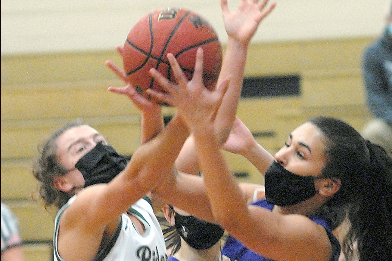 Keith Thorpe/Peninsula Daily News
Port Angeles' Jaida Wood, left, and North Kitsap's Mia McNair jostle for a rebound on Saturday evening at Port Angeles High School.