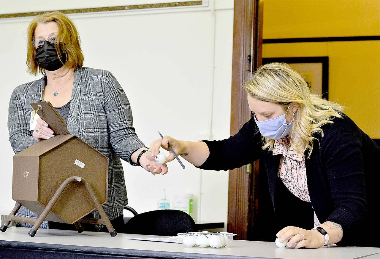 Jefferson County Auditor Rose Ann Carroll, left, and Election Coordinator Quinn Grewell used golf balls Monday morning at the Jefferson County Courthouse to conduct the lot draw for the order of candidates’ name on the primary election ballot. The Aug. 3 election includes hopefuls for Port Townsend City Council, Port Ludlow Fire District No. 3, Sequim School Board and Clallam County Fire District No. 3, which includes a portion of East Jefferson County. (Diane Urbani de la Paz/Peninsula Daily News)