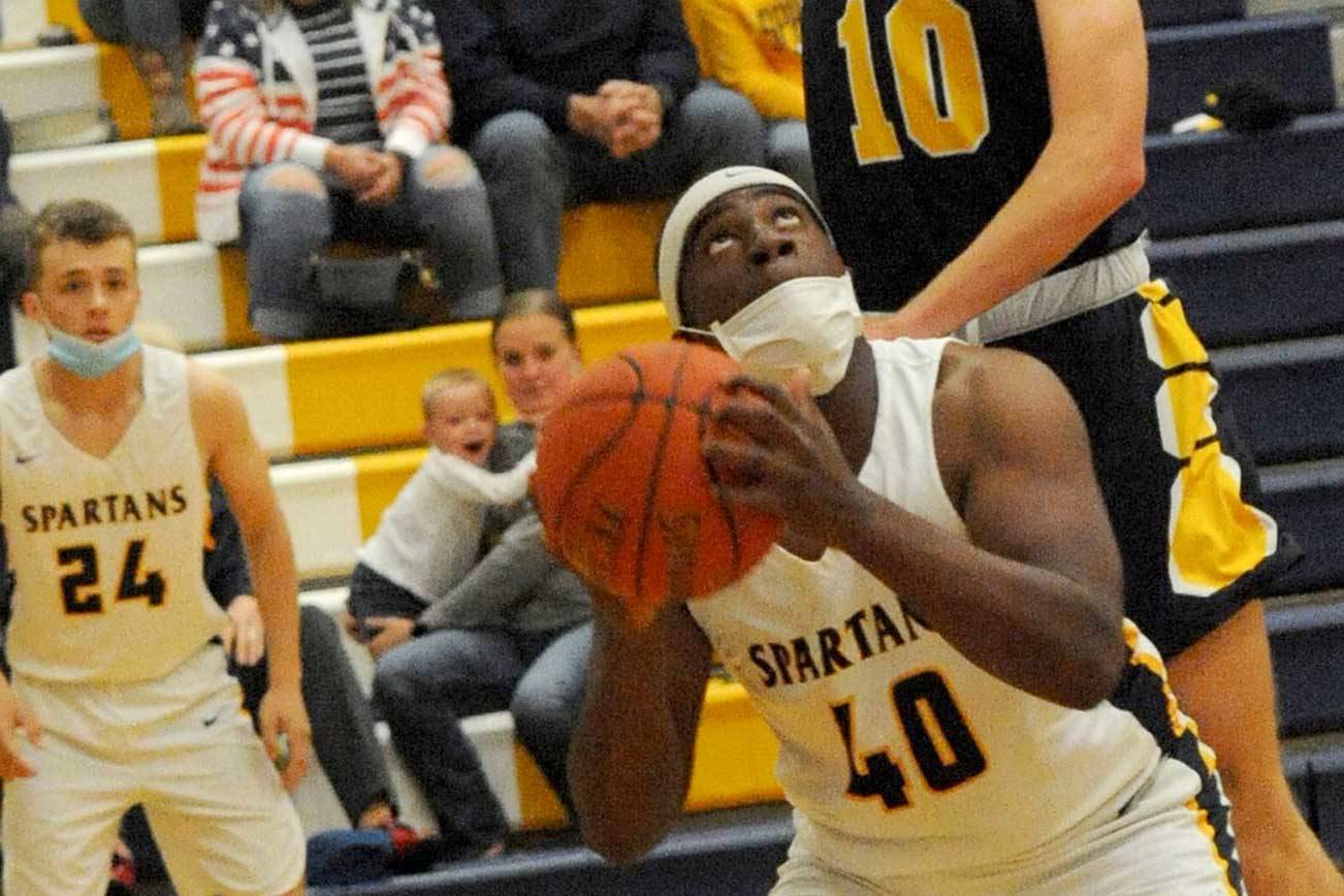 Lonnie Archibald/for Peninsula Daily News
Forks' Trey Baysinger (40) eyes the basket while Ilwaco's Jaden Turner goes over his back and commits a foul during the Spartans' 57-50 Pacific League win.