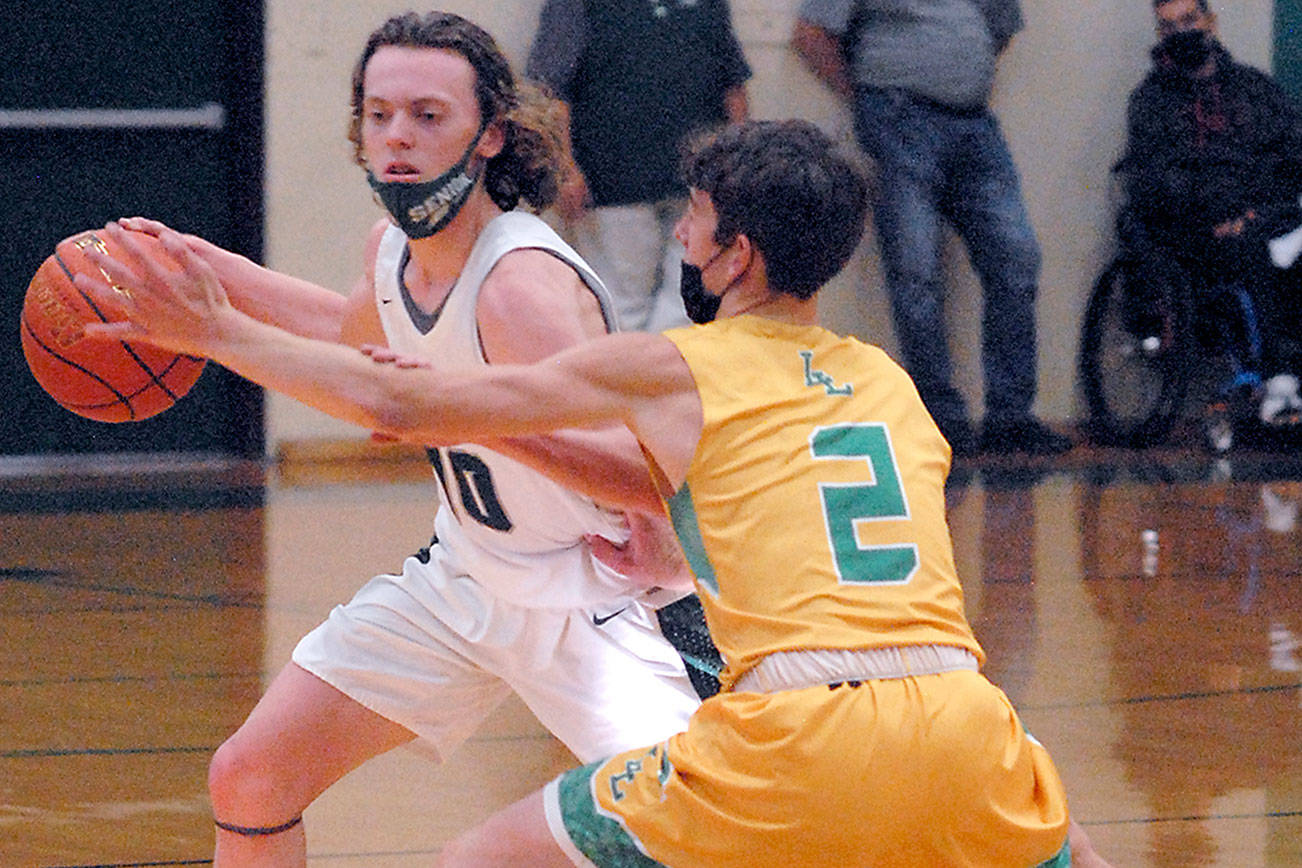 Keith Thorpe/Peninsula Daily News
Port Angeles' Dru Clark, left, tries to evade Lynden's Coston Parcher on Friday night in Port Angeles. Clark hit the game-winning runner in the final seconds as the Roughriders beat the perennial state powerhouse Lions 41-40.