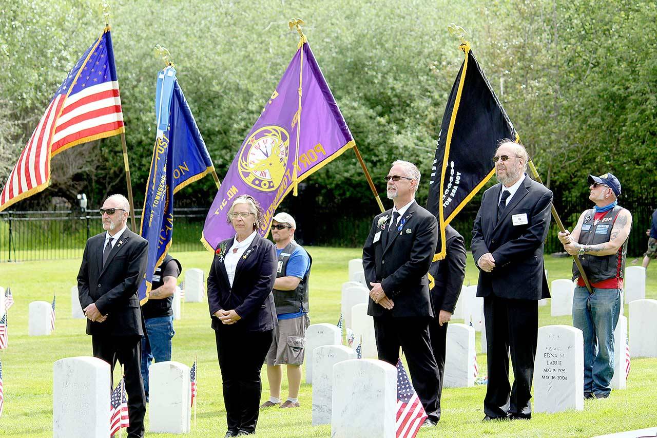 Elks Lodge 317 members, from left, Mark Banks, trustee; Shirley Beck, leading knight; James Aman, loyal knight; and Greg Carroll, chaplain, stand in front of the Marvin Shields Post 26 American Legion color guard during a joint Memorial Day ceremony Monday at the Fort Worden Cemetery. Elks trustee David Crozier carried the Elks flag as part of the day’s color guard. (Zach Jablonski/Peninsula Daily News)