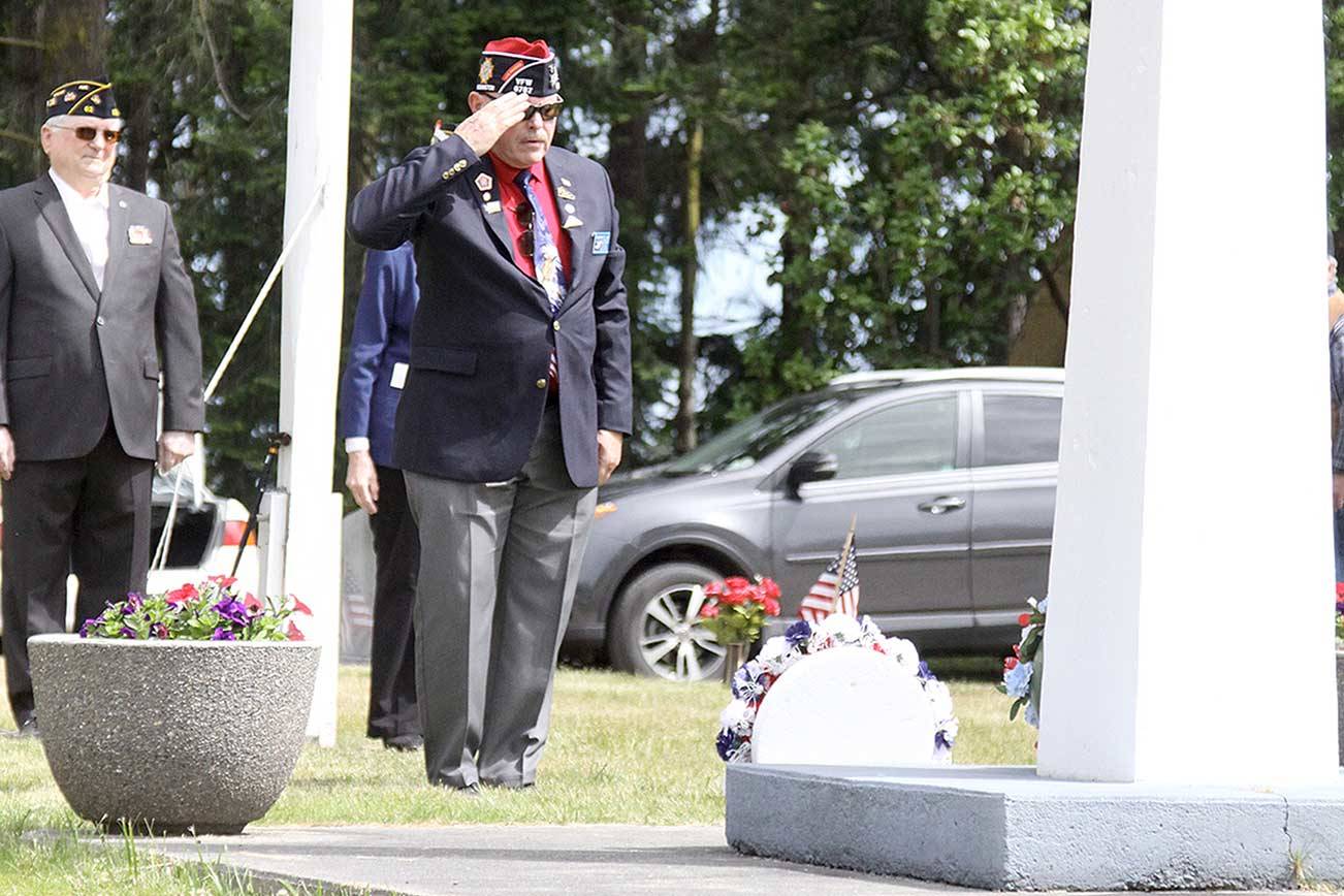 Navy veteran Rod Lee salutes a wreath he presented Monday representing VFW of Carlsborg at Sequim View Cemetery. About 100 people gathered for the short ceremony on Memorial Day to remember those who gave the ultimate sacrifice. (Dave Logan/for Peninsula Daily News)