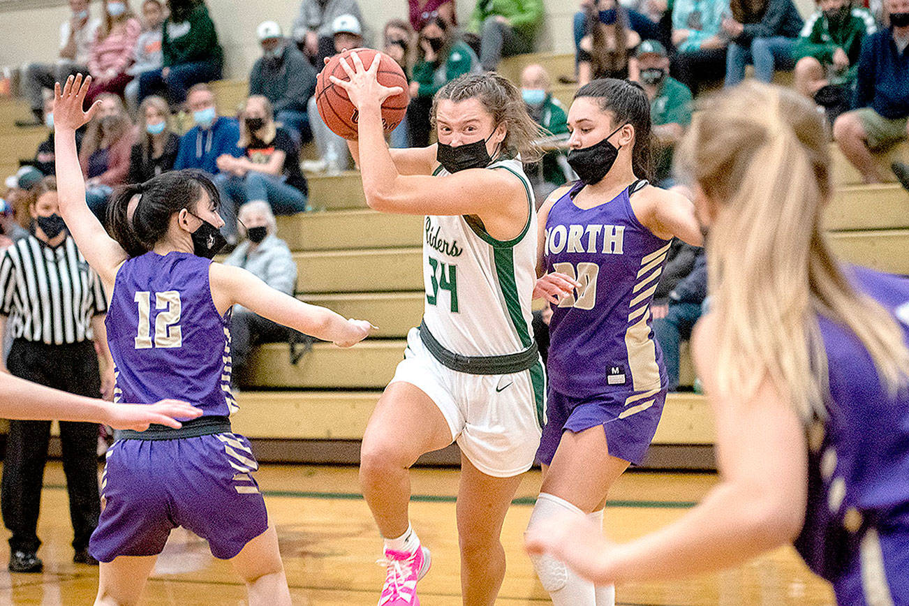 Jaida Wood of Port Angeles (34) drives around the defense of North Kitsap's Mia McNair in Monday night's Olympic League playoff win for the Roughriders. (Jesse Major/for Peninsula Daily News)