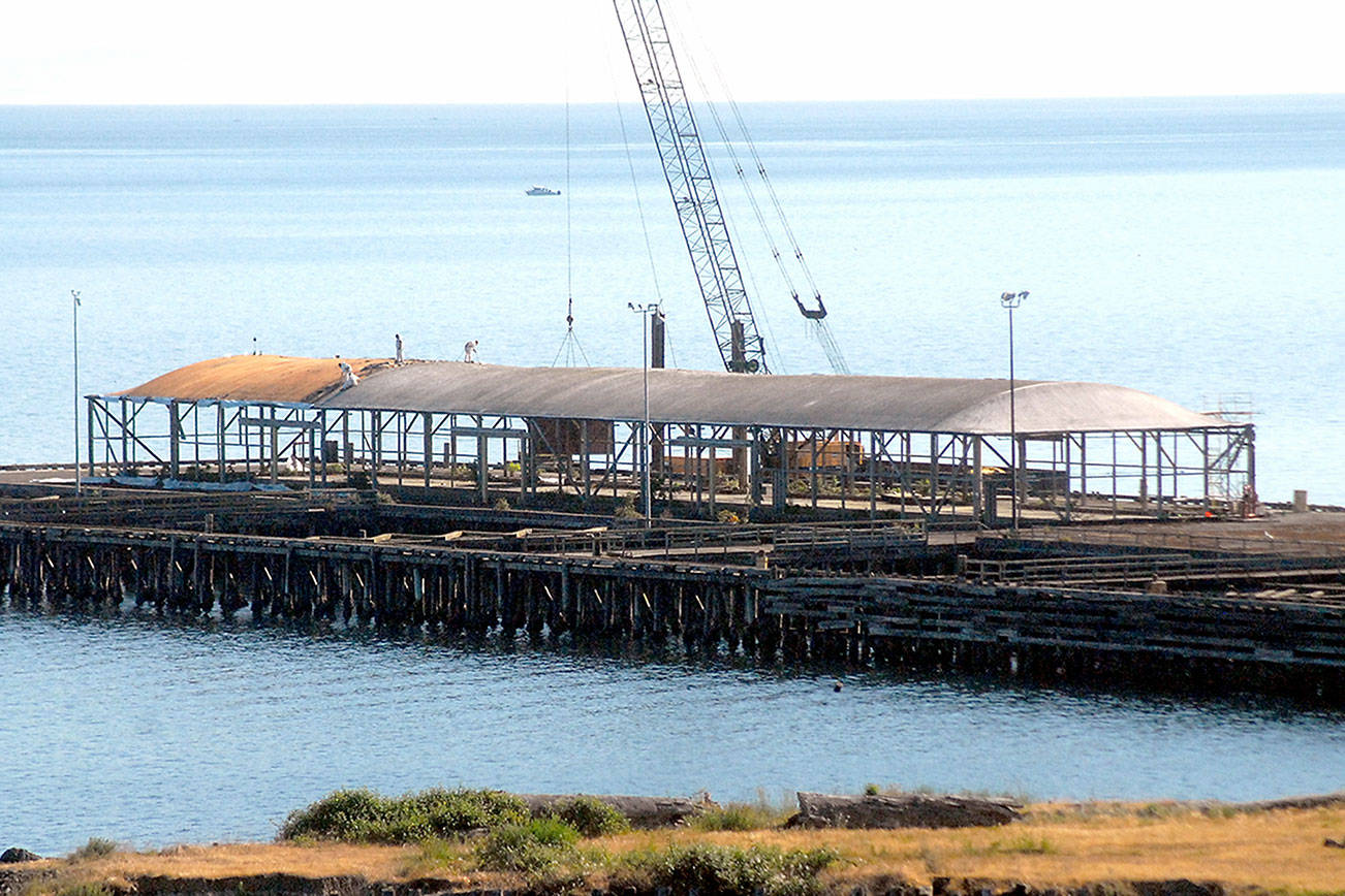 Keith Thorpe/Peninsula Daily News
Crews work on Thursday to dismantle the loading dock at the site of the former Rayonier pulp mill in Port Angeles. Workers began removing about 800 concrete dock panels this week as a step toward dismantling the 6-acre pier at the former Rayonier property 2 miles east of downtown Port Angeles. The target date for completion is July, while more than 5,000 creosote-treated pilings will not be taken out at least until 2023 as part of the overall environmental cleanup of the 75-acre former industrial site's uplands and adjacent harbor waters, a process overseen by the state Department of Ecology and paid for by property owner Rayonier Advanced Materials.