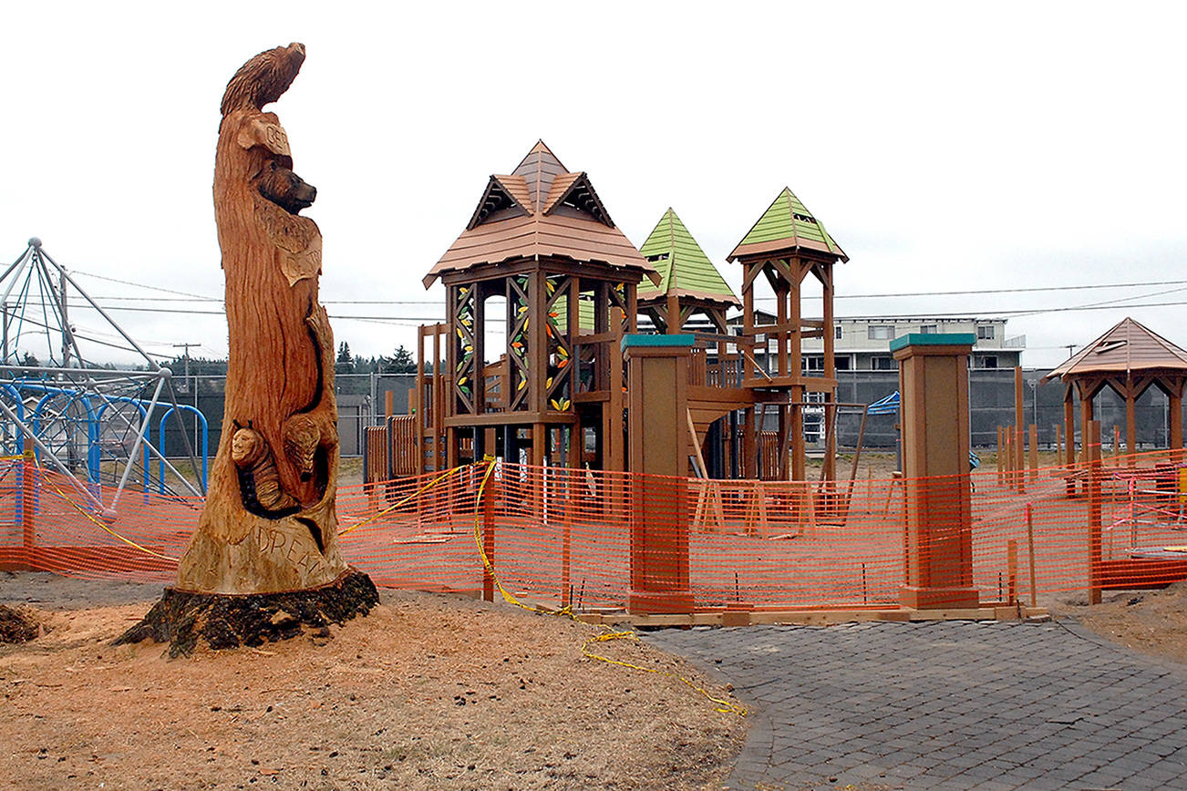 Safety fencing surrounds portions of the idled Generation II Dream Playground on Wednesday at Erickson Playfield in Port Angeles. (Keith Thorpe/Peninsula Daily News)