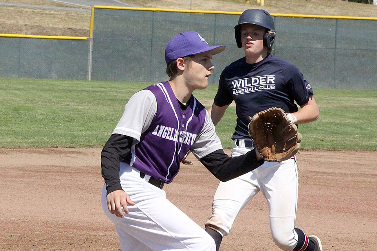 Wilder Jr baserunner Elijiah Flodstrom cruises into third base safely as the Kitsap 3rd baseman waits for the ball. 
Note: The Kitsap team you will note is wearing uniforms that say Angeles Furniture on it. The story is that all the ball players are from the Kitsap area except Jaxson Gray from Sequim. The Grays own Angeles Furniture in PA and were able to supply the whole team with uniforms with their name on it as there was a uniform problem for the Kitsap team.  dlogan