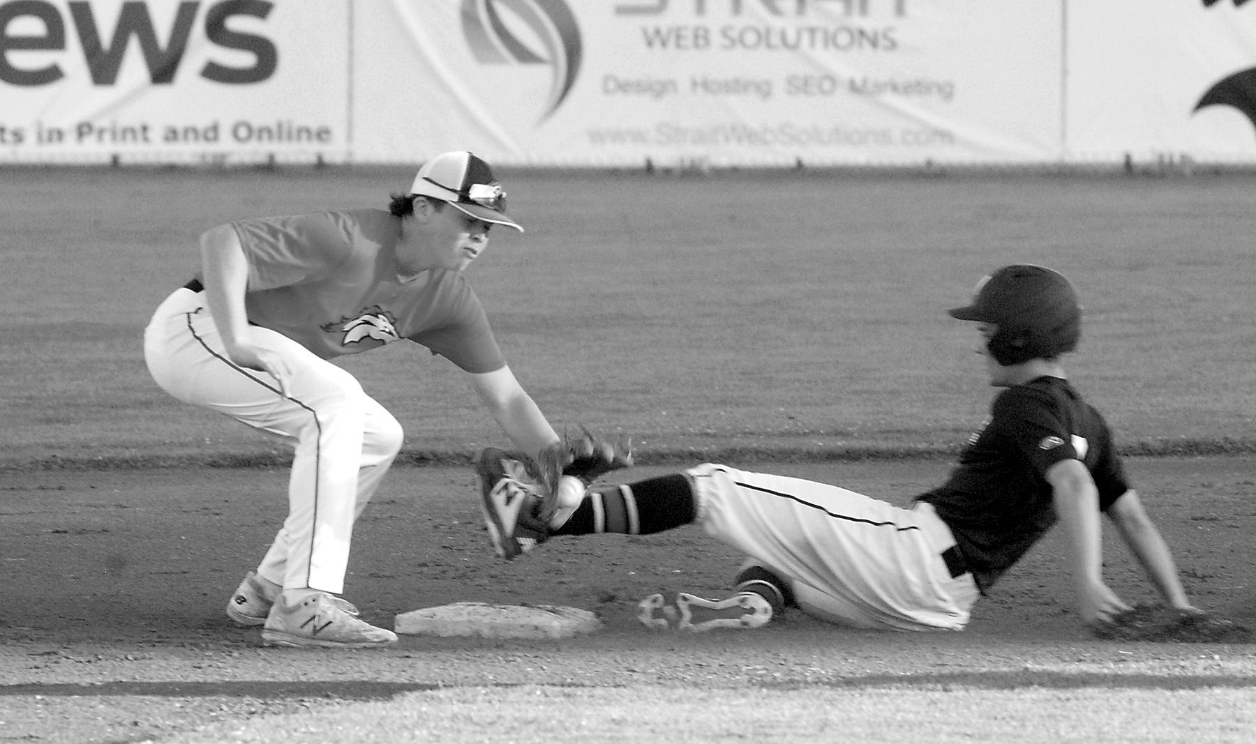 Photos by<strong> Keith Thorpe</strong>/Peninsula Daily News
Wilder’s Logan Olson, right, makes it to second, beating the throw to WBS Colts Red shortstop Grady Smith on Saturday in Port Angeles.