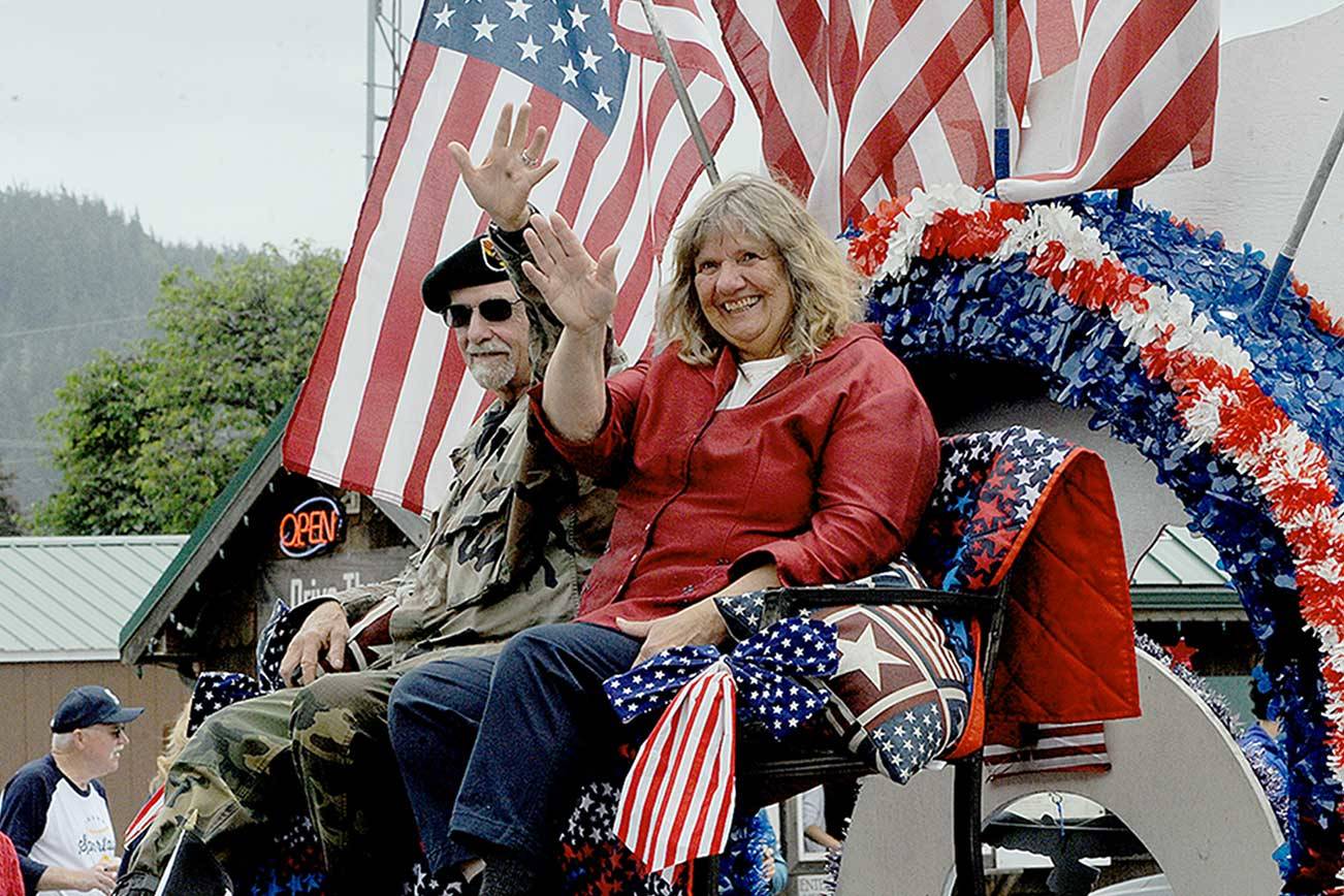 Sam McElravy, who served in the U.S. Army as Special Forces Green Beret from 1966-69, rides in a float with his wife Phyllis on Sunday during a Fourth of July parade in Forks. (Lonnie Archibald/For Peninsula Daily News)