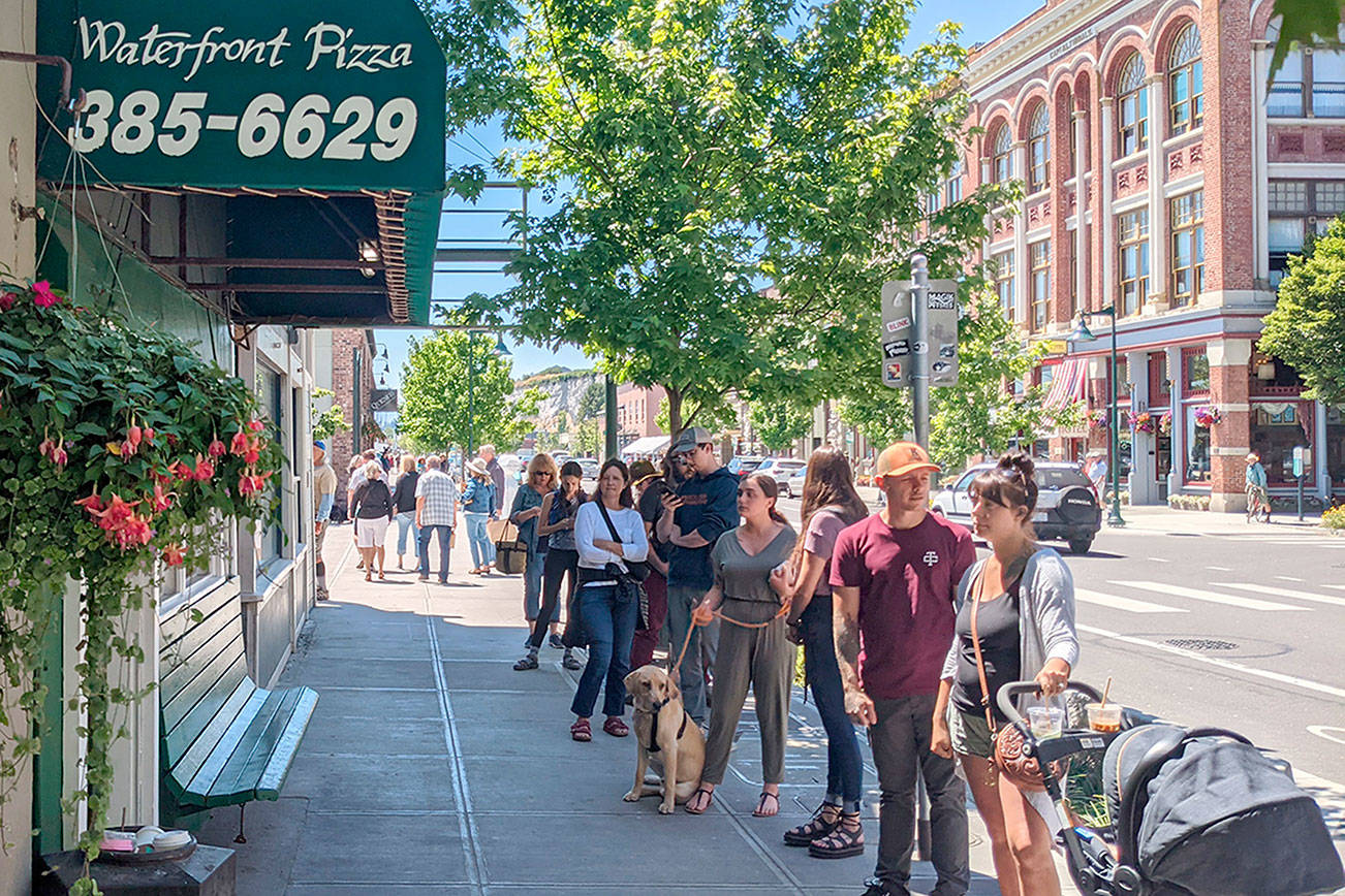 Restaurants such as Waterfront Pizza and Nifty Fifties on Water Street had lines stretching out of their buildings as large crowds of tourists packed the street Tuesday afternoon. The crowds were in sharp contrast to the sparse tourist season the community saw last summer after the COVID-19 pandemic began. The nice weather is expected to continue through the end of next week with temperatures ranging from the mid-60s to mid-70s. (Zach Jablonski/Peninsula Daily News)