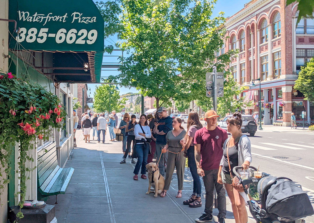 Restaurants such as Waterfront Pizza and Nifty Fifties on Water Street had lines stretching out of their buildings as large crowds of tourists packed the street Tuesday afternoon. The crowds were in sharp contrast to the sparse tourist season the community saw last summer after the COVID-19 pandemic began. The nice weather is expected to continue through the end of next week with temperatures ranging from the mid-60s to mid-70s. (Zach Jablonski/Peninsula Daily News)