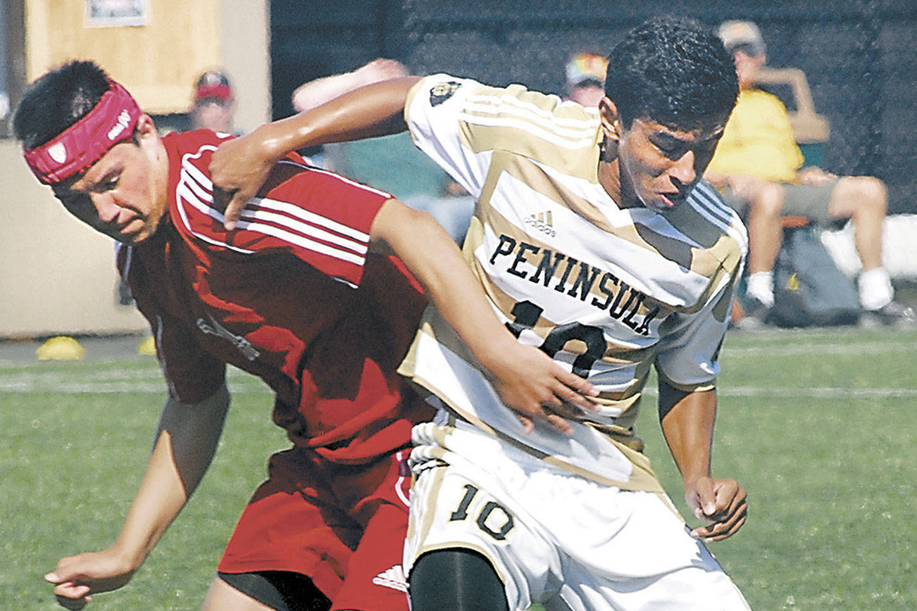 Keith Thorpe/Peninsula Daily News
Southwestern Oregon's Zachary Barker, left, battles with Peninsula's Erick Urzua in 2013 in Port Angeles. The NWAC-champion 2012 and 2013 Pirate men's and women's soccer teams will be inducted into the Pirates Hall of Fame along with longtime basketball scorekeeper Bill Peterson on Sept. 25.