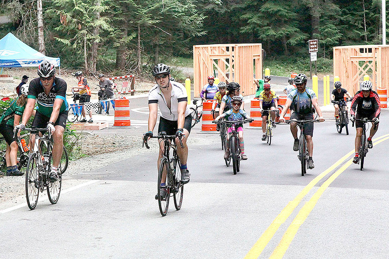 A group of Ride the Hurricane riders pass the new entrance station being built on Hurricane Hill Road. Elinor Jones, 9, from Sequim, was one of the youngest riders in the event that climbs 17 miles and 5,242 feet of elevation to the top of Hurricane Ridge. (Dave Logan/for Peninsula Daily News)