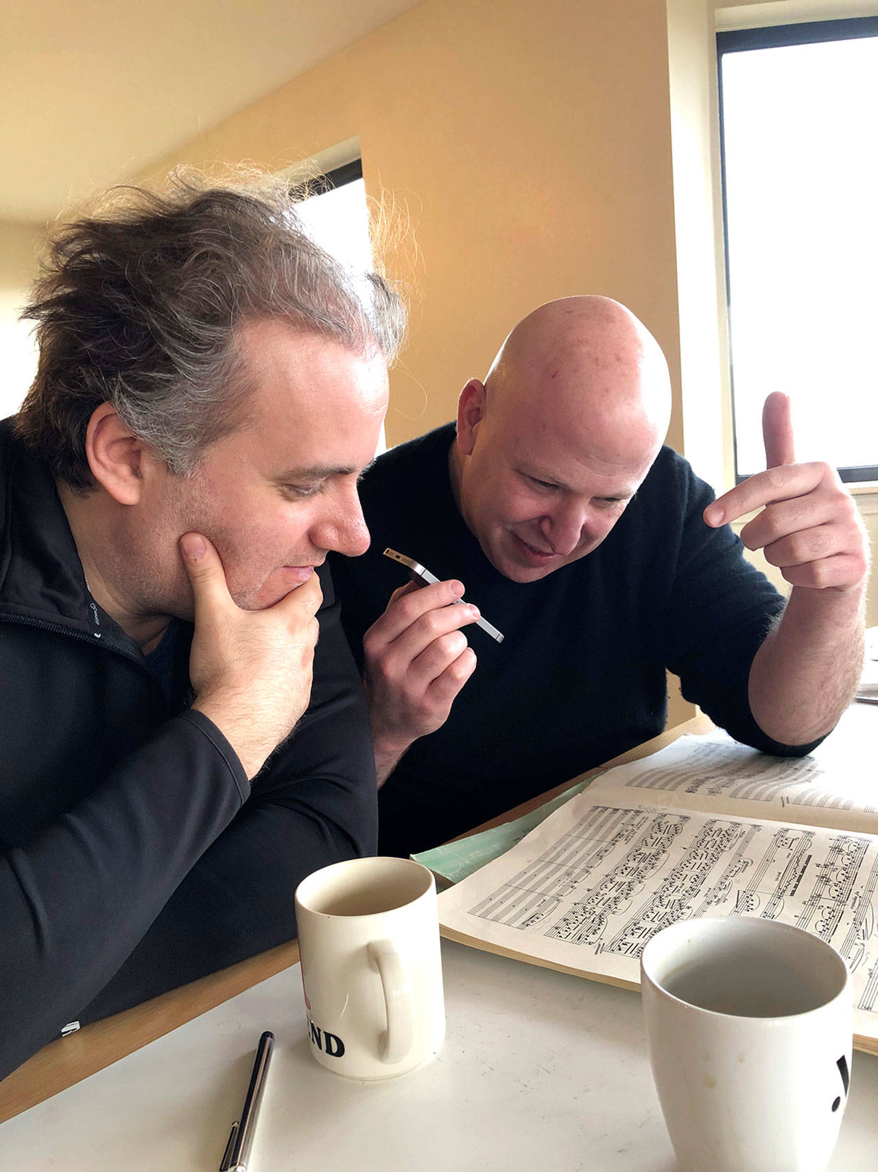 Pianist Josu de Solaun, left, and Port Angeles Symphony conductor Jonathan Pasternack, pictured in Port Angeles in February 2020, pore over the music they will record this month in the Czech Republic. (Photo by Dorthe Grube Porter/Port Angeles Symphony)