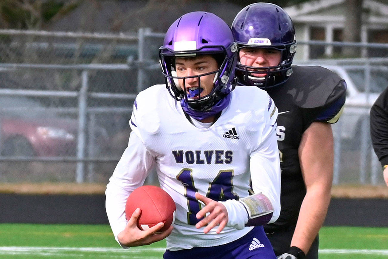 Sequim quarterback Kobe Applegate avoids North Kitsap defenders during a contest last spring. Applegate is expected to start at quarterback his senior season. (Michael Dashiell/Olympic Peninsula News Group)