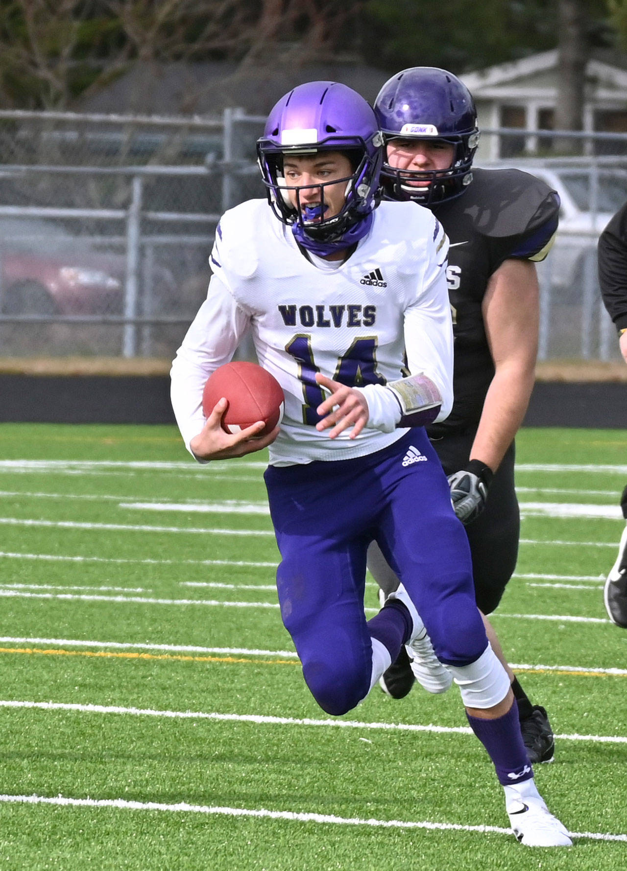 Sequim quarterback Kobe Applegate avoids North Kitsap defenders during a contest last spring. Applegate is expected to start at quarterback his senior season. (Michael Dashiell/Olympic Peninsula News Group)