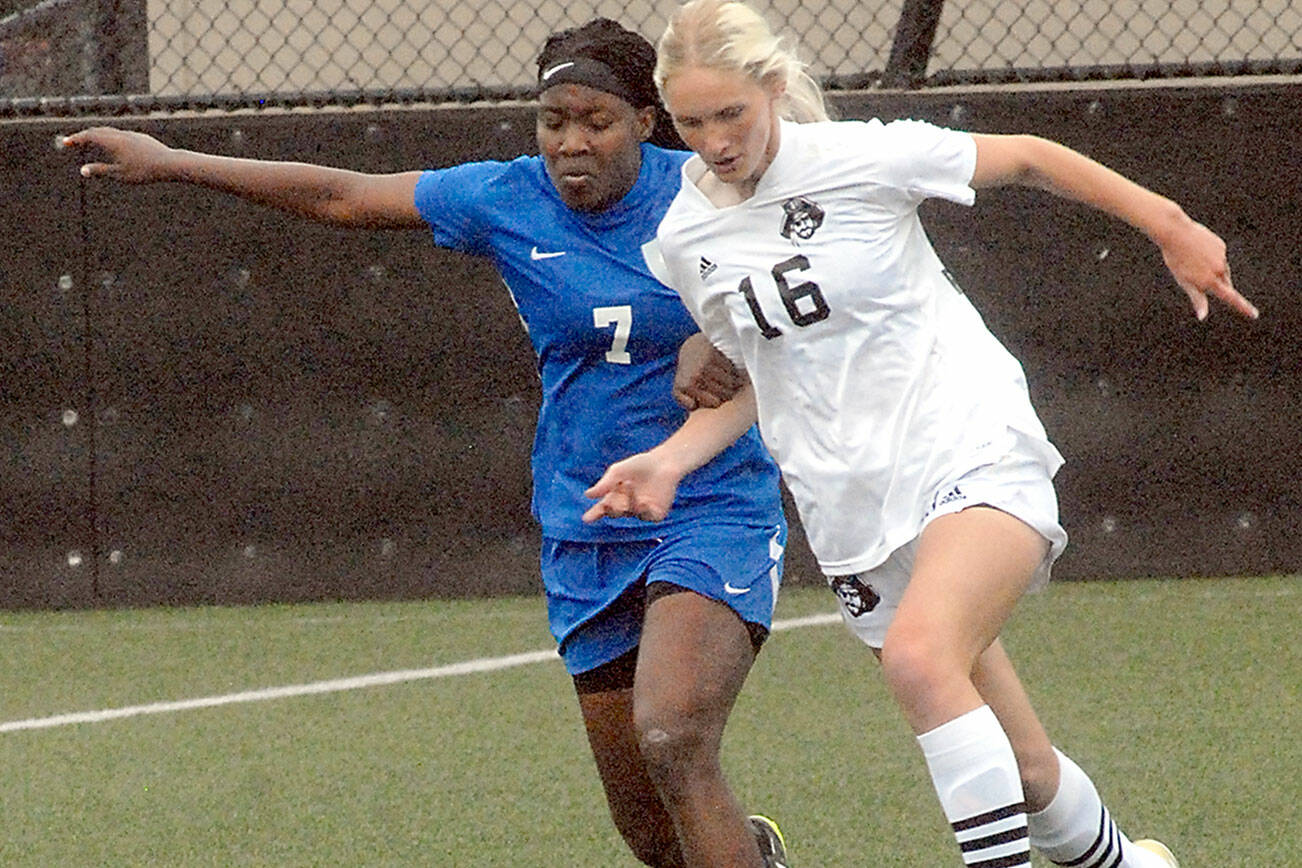 Peninsula's Millie Long, a graduate of Port Angeles High School, right, tries to outrace Edmonds' Flero Dina Surpris on Wednesday at Wally Sigmar Field in Port Angeles. (Keith Thorpe/Peninsula Daily News)