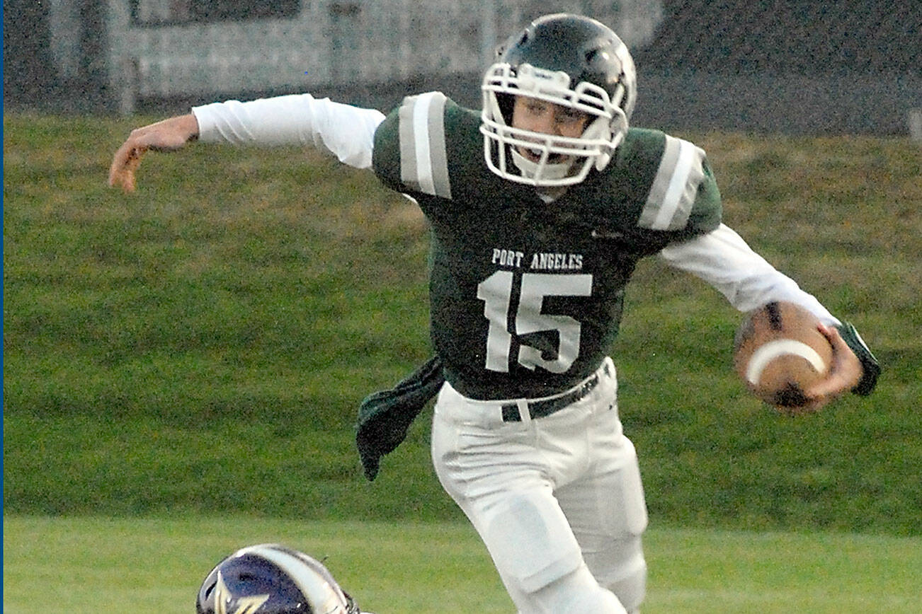 Keith Thorpe/Peninsula Daily News
Port Angeles quarterback Parker Nickerson gets tripped up on a short run by North Kitsap's Benen Lawler on Friday night at Port Angeles Civic Field.