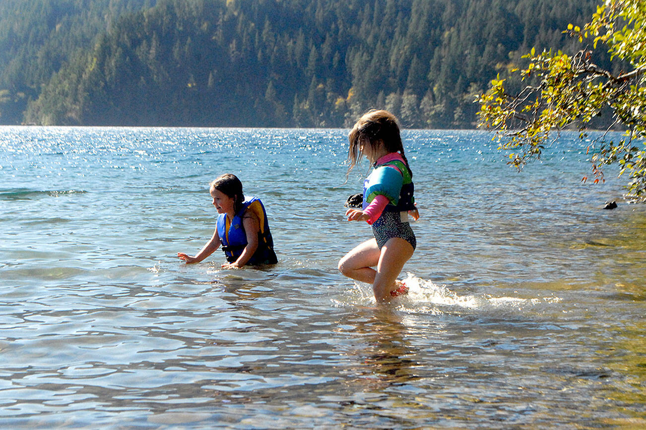 Normajane Goodfellow, 4, left, and Minue Garling, 5, both of Port Angeles, cavort in the waters of Lake Crescent in Olympic National Park over the weekend. The youth were on a family outing to East Beach Road. (Keith Thorpe/Peninsula Daily News)