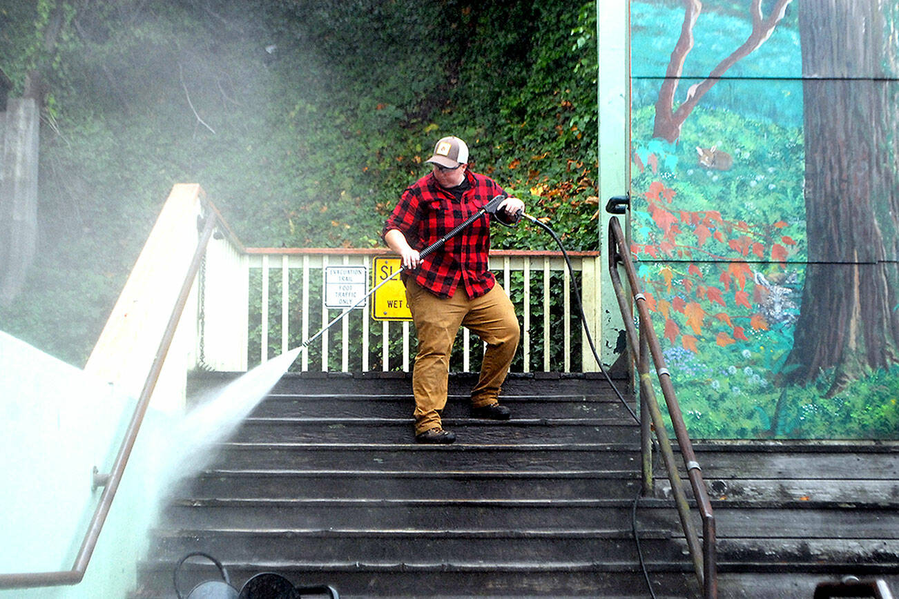 Port Angeles Parks & Recreation Department employee Jessica Adams pressure washes the Laurel Street stairs behind the Conrad Dyar Memorial Fountain in downtown Port Angeles on Wednesday. (Keith Thorpe/Peninsula Daily News)