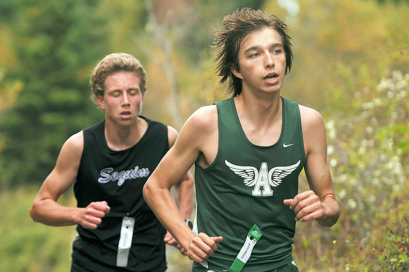 Michael Dashiell/Olympic Peninsula News Group

Port Angeles' Max Baeder, right, races with Sequim's Colby Ellefson during a 3.1-mile Olympic League cross-country race at Voice of America at Dungeness Recreation Area. Ellefson ended up edging out Baeder for second place.