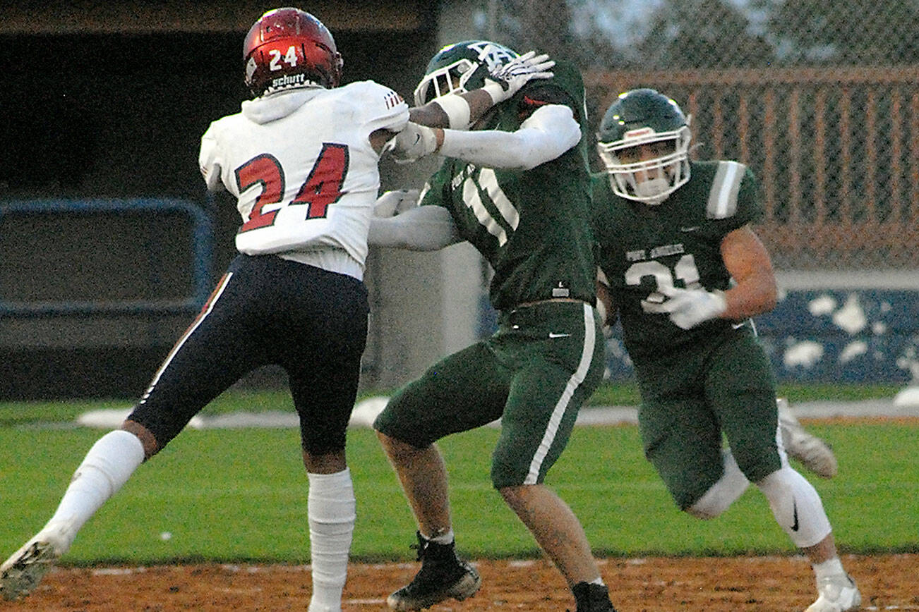 Keith Thorpe/Peninsula Daily News
Port Angeles' Ty Bradow, center, fends off Kennedy Catholic's Xe'Ree Alexander as Roughrider Daniel Cable tries to slip past with the ball on Friday at Port Angeles Civic Field.