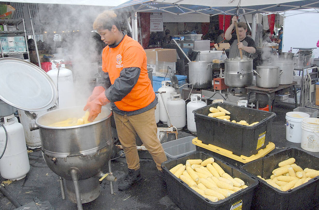 Volunteer corn cook Xavion Mason of Bakersfield, Calif., adds fresh ears to a boiler behind the scenes at the 2019 Dungeness Crab and Seafood Festival. (Keith Thorpe/Peninsula Daily News)