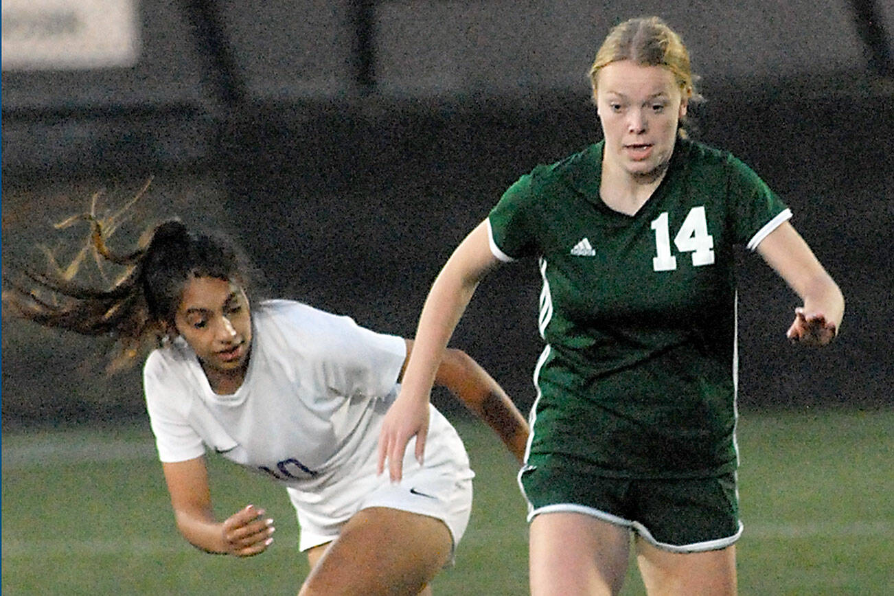 Keith Thorpe/Peninsula Daily News
Port Angeles' Anna Petty, right, pushes past Sequim's Jennyfer Gomez on Tuesday at Peninsula College in Port Angeles.