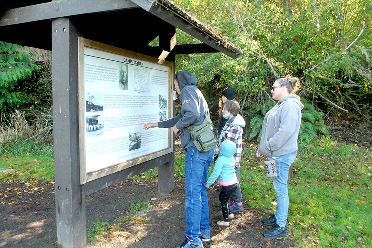 Members of the Pease family of Sequim, from left, father, Craig, children Addison, 12, Alayna, 10 and Alivia, 3, and mother, Bambi, examine an information kiosk at Salt Creek Recreation Area north of Joyce last week. The group was exploring places on the North Olympic Peninsula. (Keith Thorpe/Peninsula Daily News)