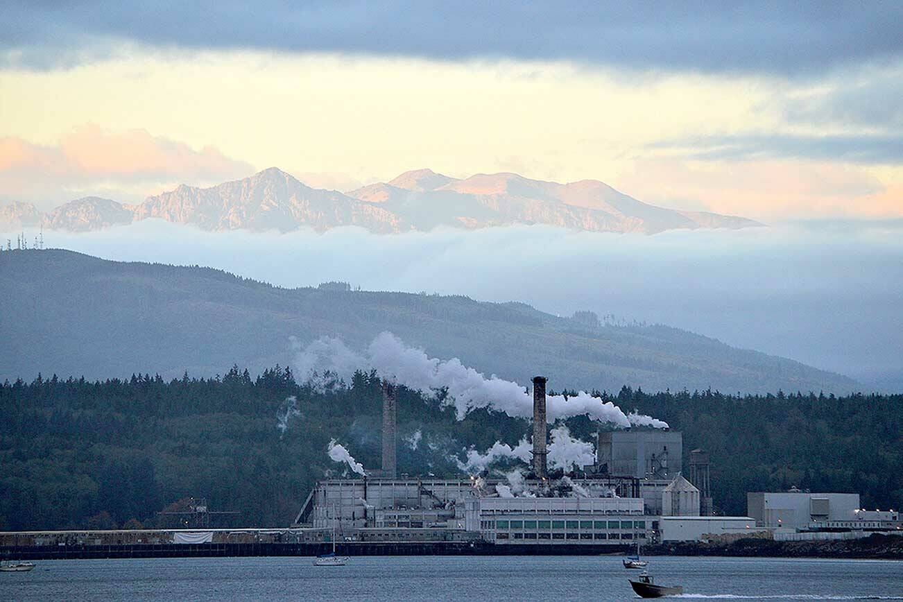 Soon after dawn, clouds part to reveal the Olympic Mountains high above the Port Townsend Paper mill from the Washington State Ferry dock in Port Townsend. Sunrise will come about 90 seconds later each morning through the solstice on Dec. 21. (Diane Urbani de la Paz/Peninsula Daily News)