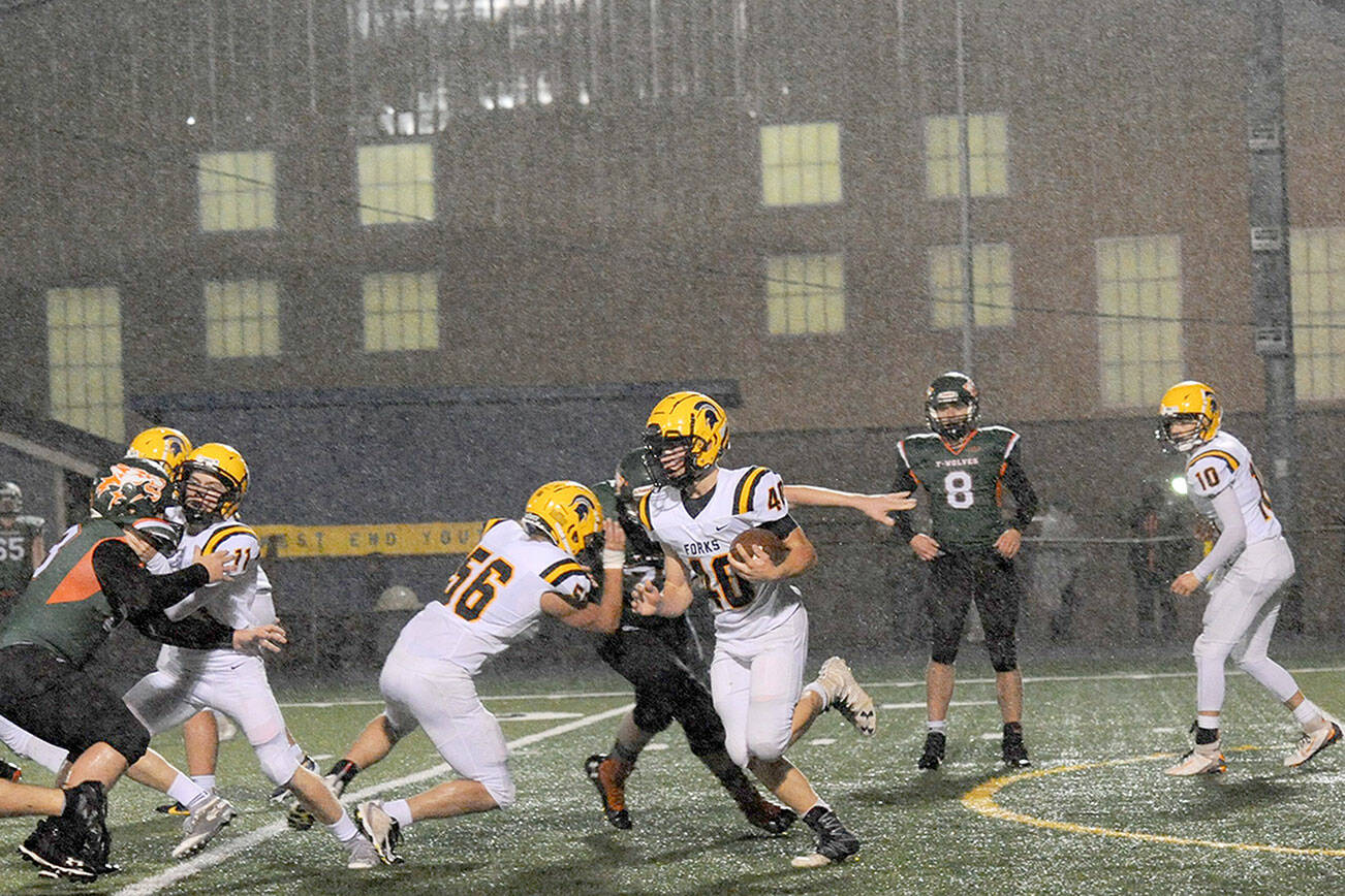 image 11=Spartan running back Nate Dahlgren (40) picks up more big yardage behind the blocking of Conner Earls (56) and Kalab Blanton (11),  It was a big night for both the Forks offense and defense against the Morton-White Pass Timberwolves on Homecoming Night at Spartan Stadium..  Photo by Lonnie Archibald.