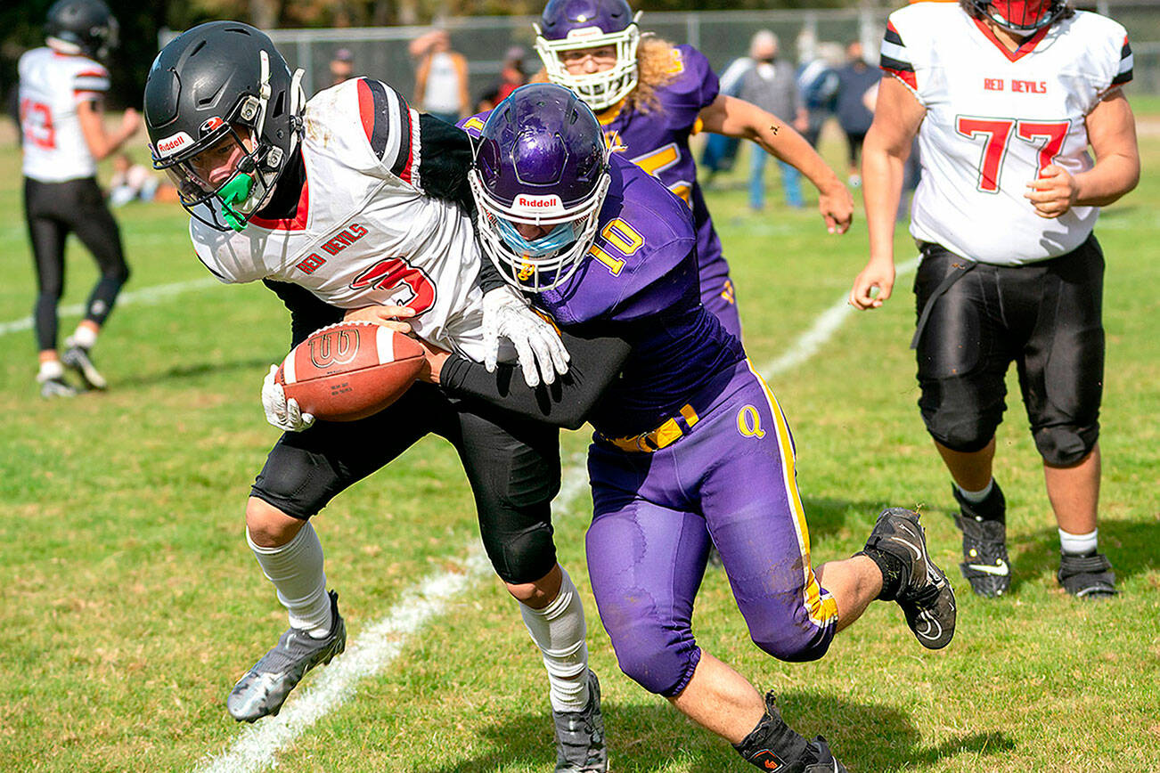 Neah Bay's Neil Bowechop is tackled by Quilcene's James Miller (10) as the Rangers' Jeremy Allen (15) and Neah Bay's Azriel Swan-Jimmicum (77) are in on the play. (Steven Mullensky/for Peninsula Daily News)