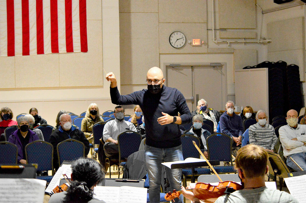 Conductor Tigran Arakelyan rehearses Friday night with the Port Townsend Symphony Orchestra before a small live audience at the American Legion Hall. Today the ensemble will give its first public performance since early 2020; the 2 p.m. concert is sold out, but the orchestra plans another one on Dec. 4. Information can be found at PTsymphony.org. Diane Urbani de la Paz/Peninsula Daily News