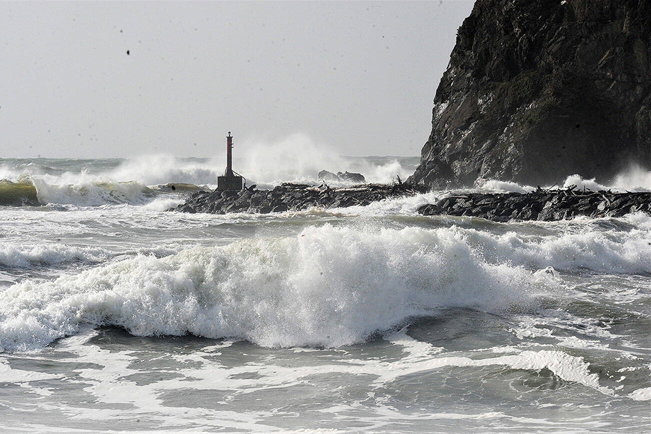 Waves and foam erupt from the Pacific Ocean during high tide at the mouth of the Quillayute River in La Push. In the distance is James Island and the marker light at the river’s mouth. Strong winds and rain pummeled the Peninsula on Sunday. (Lonnie Archibald/for Peninsula Daily News)