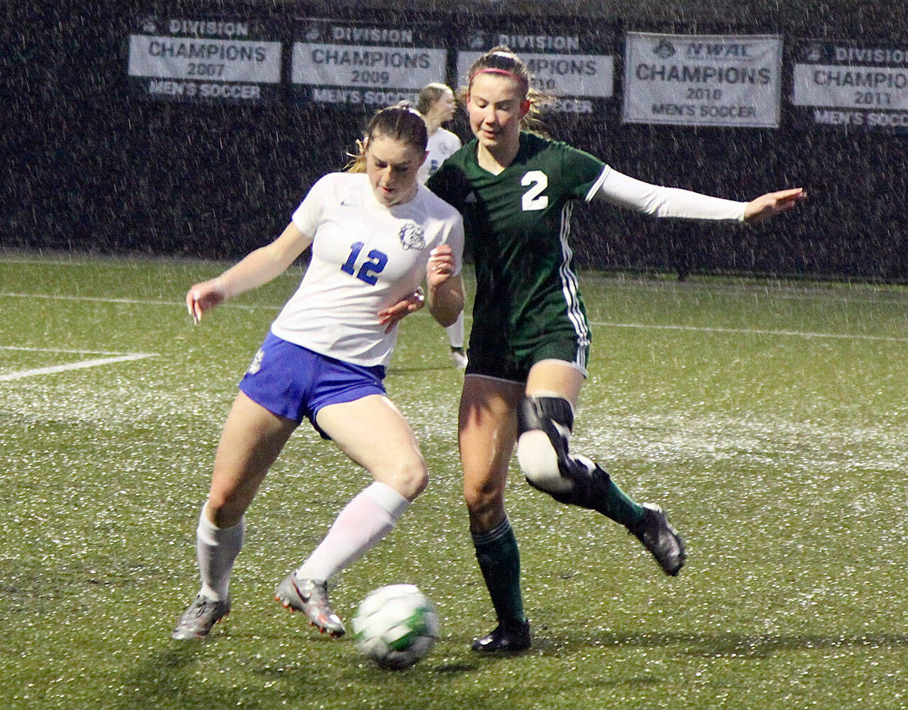 Grace Smelcer of the North Mason (12) fights with Catie Brown (2) of Port Angeles in a steady downpour Monday at Wally Sigmar Field. Port Angeles won the game 6-0. (Dave Logan/for Peninsula Daily News)