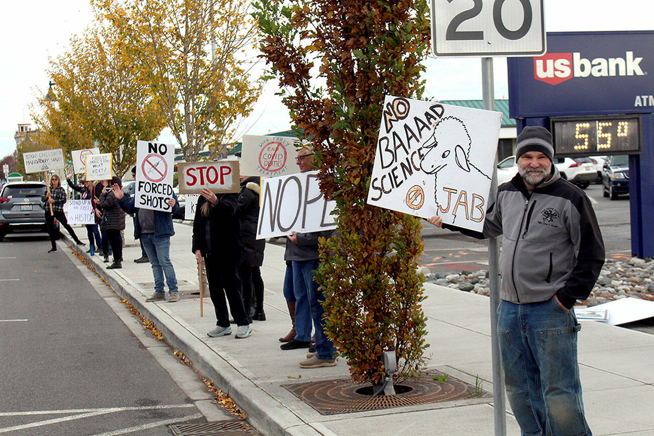 About 50 people lined the sides of Water Street in Port Townsend near the ferry terminal Wednesday morning, as part of the "World Wide Walkout" created by the National Health Freedom Coalition in opposition to COVID-19 vaccination mandates. According to the Coalitions event page: "Citizens around the globe are protesting loss of liberty, illegal mandates and tyrannical government overreach."
Signs carried by local residents held a variety of sayings, with different versions of calling for no mandates or forced vaccinations, "my body my choice", shirts that said "we will not comply", and that the mandates violated the U.S. Constitution. (Zach Jablonski/Peninsula Daily News)