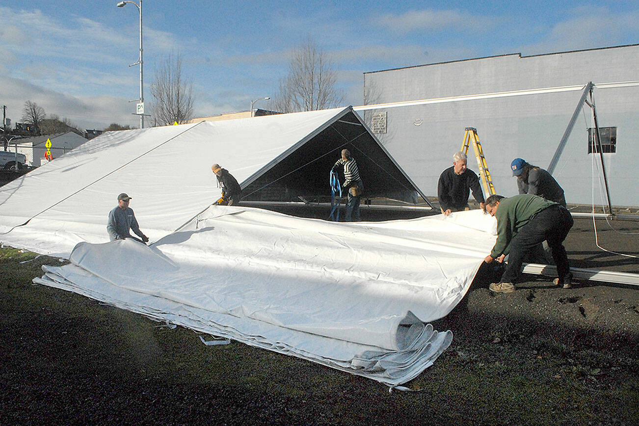 Keith Thorpe/Peininsula Daily News
A work crew erects a tent on Wednesday that will cover a temporary ice skating rink to be installed for the annual Winter Ice Village in the 100 block of West Front Street on downtown Port Angeles. Daily ice skating will begin on Nov. 19 and continue through Jan. 3.