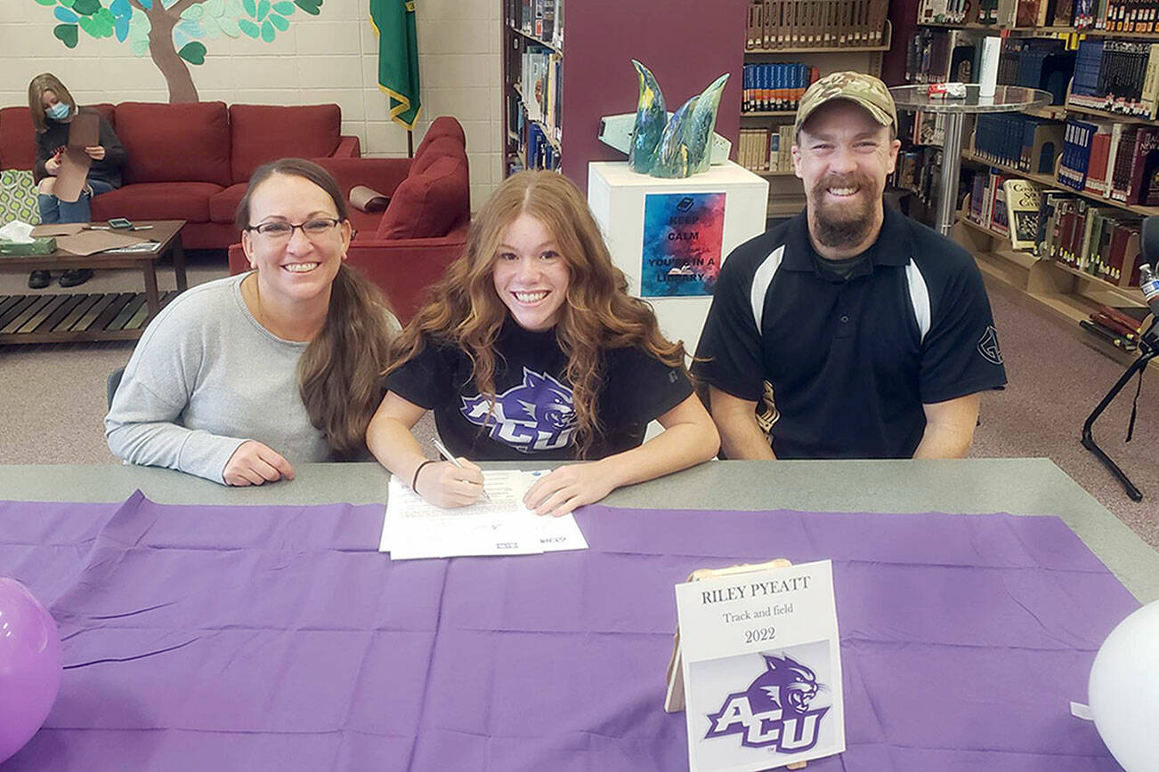 Sequim School District
Sequim senior Riley Pyeatt, center, signs her Letter of Intent to run track at Abilene Christian University in Abilene, Texas.  The Wildcats are a member of the NCAA Division I Western Athletic Conference.  Pyeatt recently finished her senior cross country season with a fifth-place at the Class 2A state meet in Pasco. She is joined by mom Tracie and dad Doug Pyeatt.