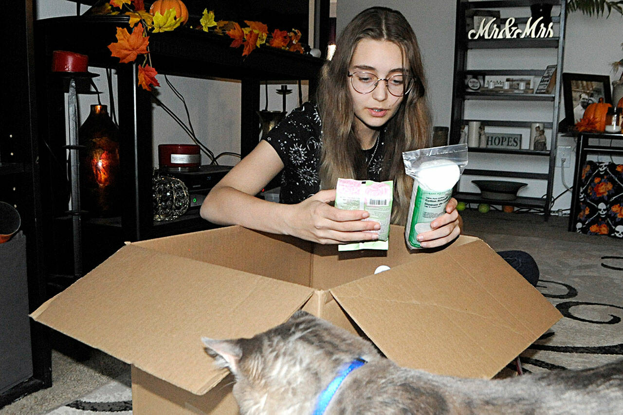 River Jensen, 15, sorts one of the many boxes of toiletries she plans to distribute to local agencies prior to Christmas. She’s donated thousands of bags to in-need individuals across Clallam County. (Matthew Nash/Olympic Peninsula News Group)