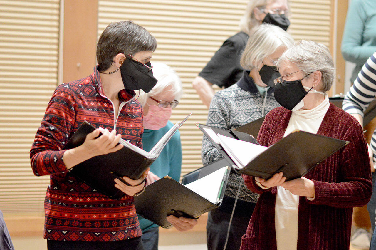 In rehearsal earlier this week, RainShadow Chorale sopranos — from left, Elizabeth Bindschadler, Marci Melvin, Katy Ottaway and Patricia Hauschildt — take a quick breather. The chorale will give its first concerts in two years tonight and Saturday. (Diane Urbani de la Paz/Peninsula Daily News)