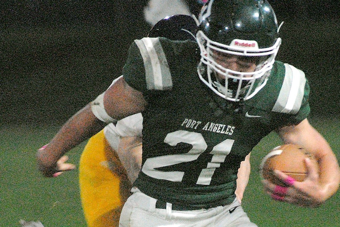 Keith Thorpe/Peninsula Daily News
Port Angeles' Daniel Cable escapes the Bainbridge defense on Friday night at Port Angeles Civic Field.