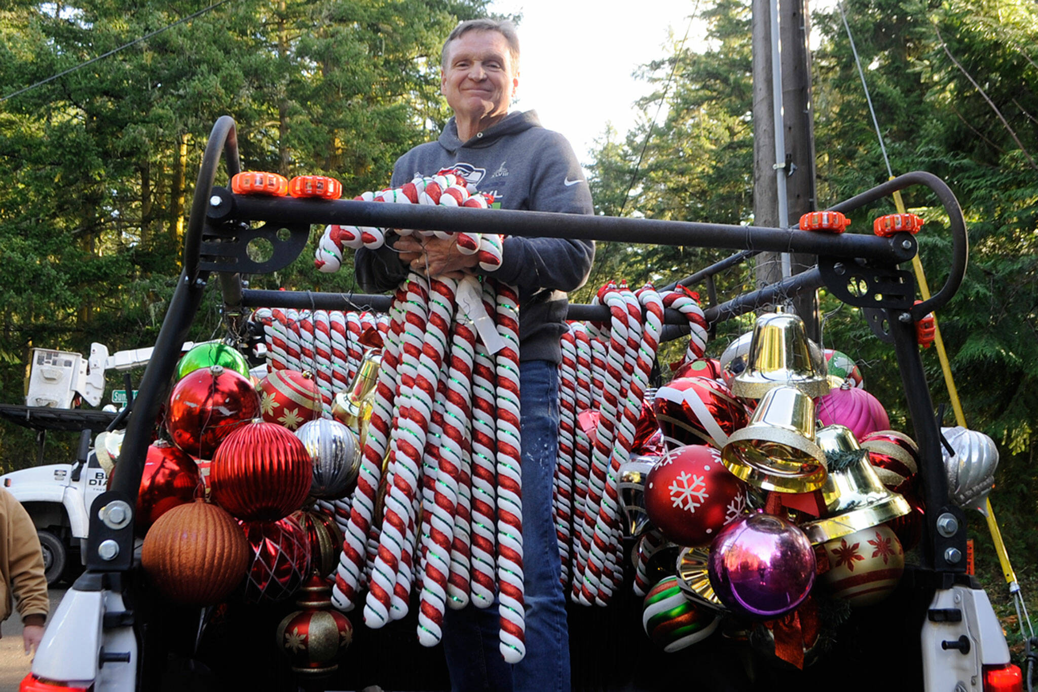 <strong>Matthew Nash</strong>/Olympic Peninsula News Group
Craig Tenhoff prepares to hand off candy canes to place along Diamond Point Road earlier this month as the road was transformed into Holiday Lane. Each year since 2007, residents have lined the road with Christmas decorations for nearly 4 miles starting from the road’s intersection at U.S. Highway 101. About 35 volunteers helped hang ornaments, candy canes and banners.