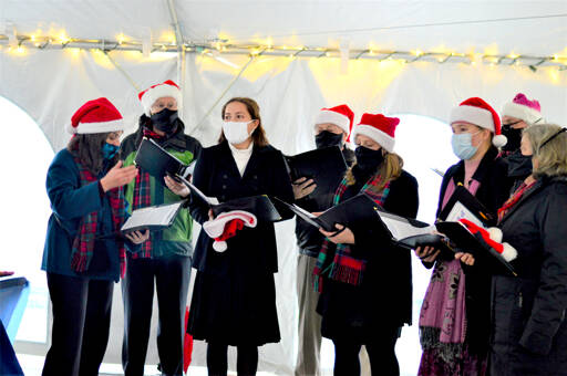 The a cappella Wild Rose Chorale, caroling in downtown Port Townsend earlier this month, will give the first in-person Candlelight Concert in 20 months this Thursday at Trinity United Methodist Church. The members are, from left, director Leslie Lewis, Doug Rodgers, Viola Frank, Al Thompson, Sarah Gustner-Hewitt, Eugenia Frank, Steve Duniho and Lynn Nowak; not pictured is Chuck Helman. (Diane Urbani de la Paz/Peninsula Daily News)