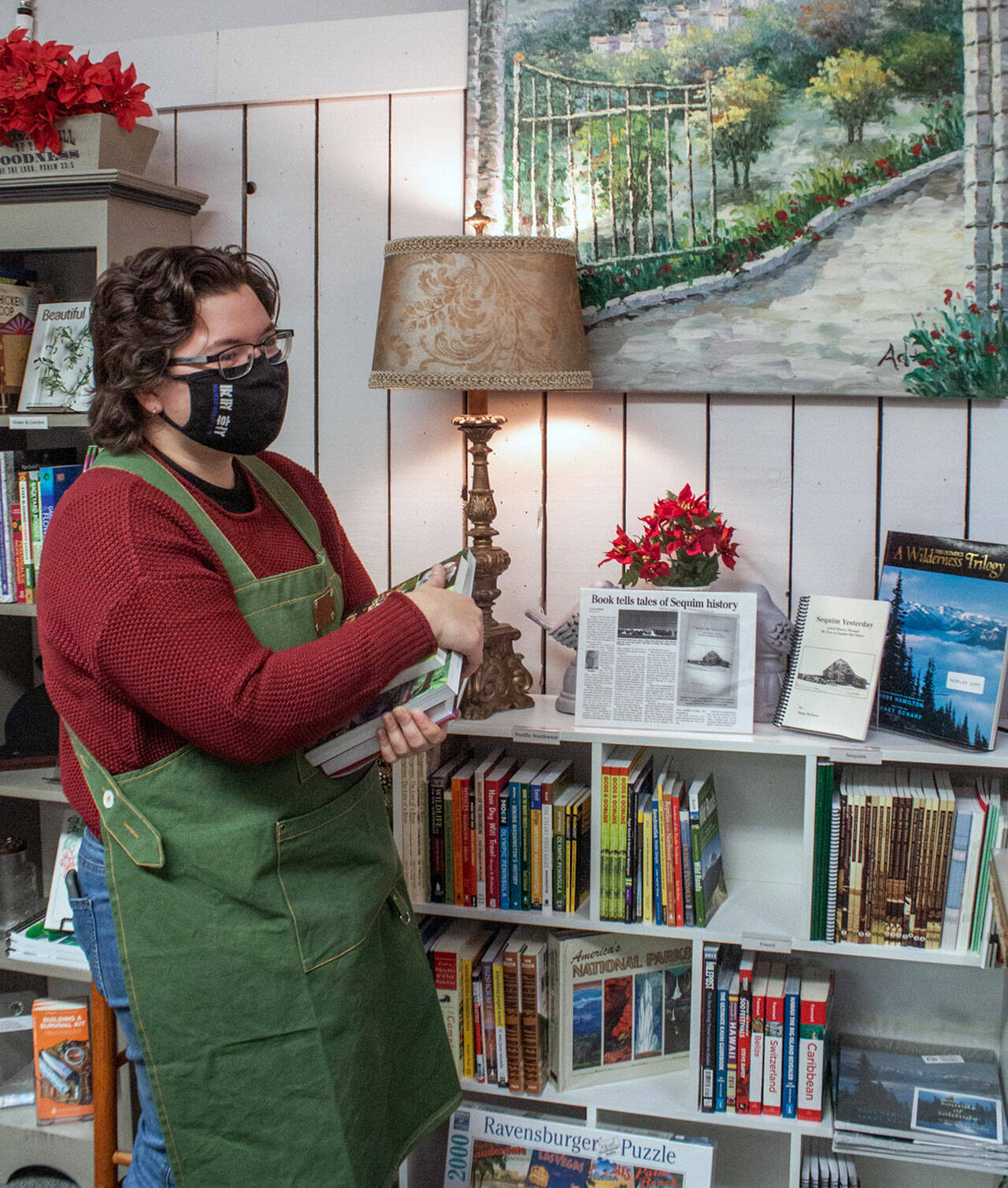 Pacific Mist sales associate Caitlin Knapple shelves books in the local section of the newly opened book and gift store. (Sequim Gazette photo by Emily Matthiessen)