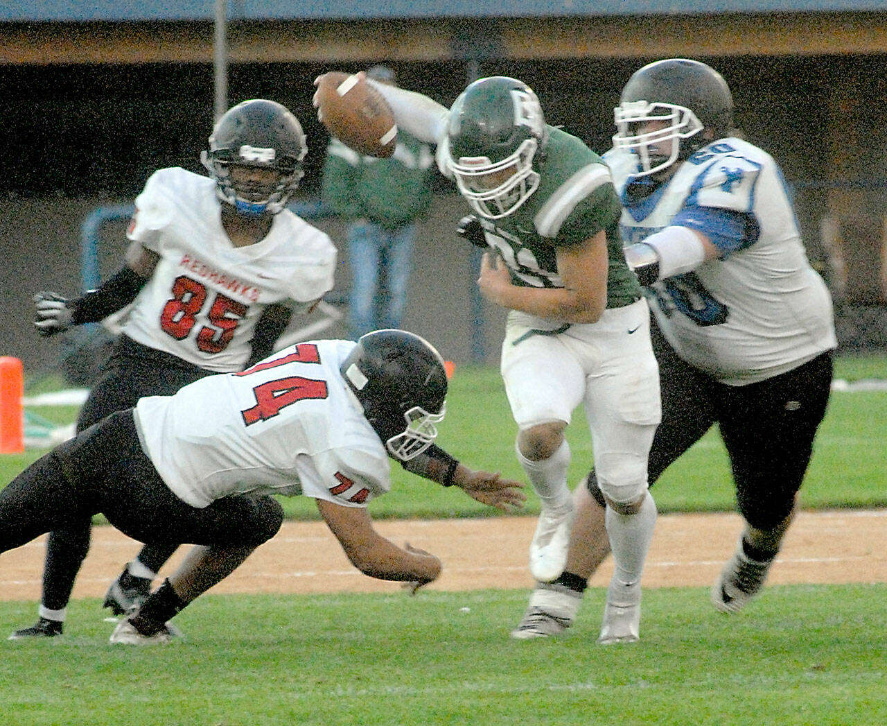 Keith Thorpe/Peninsula Daily News Port Angeles’ Daniel Cable, center, weaves around East Jefferson defenders, from left, Malachi Azariah McDonald, Gerald Lindsey and Christopher Fair on Friday in Port Angeles.