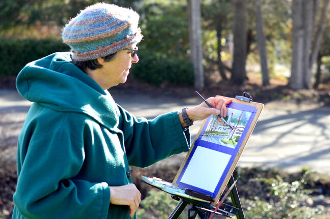 Madeline Nelson of Port Townsend works in watercolors and bright sun on the grass outside the Jefferson County Courthouse. The plein air painter typically spends just an hour finishing a piece before her hands get too cold. (Diane Urbani de la Paz/Peninsula Daily News)