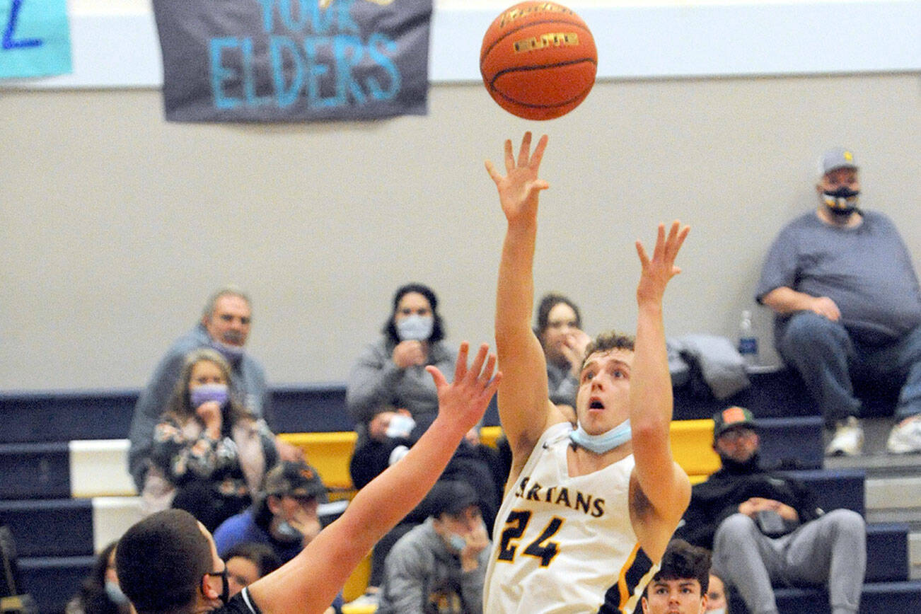 Lonnie Archibald/for Peninsula Daily News
Forks' Logan Olson scores over Neah Bay in a fast-paced contest in which the Spartans prevailed 62-54 over the Red Devils.